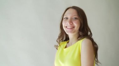 sarı elbiseli güzel kız gülüşü gösterir. Kameraya gülümse