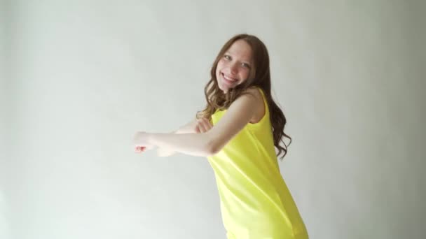 Συναισθηματική κορίτσι με αισθησιακά χείλη σε γκρι φόντο. Πορτρέτο του όμορφη μελαχρινή σε φωτεινό κίτρινο φόρεμα — Αρχείο Βίντεο