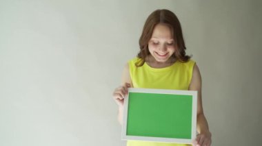 Gri bir arka plan üzerinde ellerini chromakey işaretli bir çekici kadın.