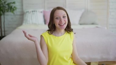 Bir video blog yapmak için kamera önünde konuşurken sarı elbiseli kadın.