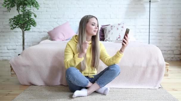 Красива молода жінка вдома сидить на підлозі і розмовляє по телефону . — стокове відео
