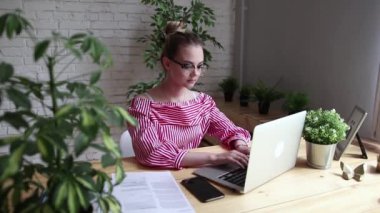 Masada oturan, dizüstü bilgisayar ekranına bakarak, görüntülü görüşme sahip mutlu işadamı gülümseyerek. Video aramasý sahip genç iş kadını. Güzel bir kadın onu laptop üzerinde çalışıyor.