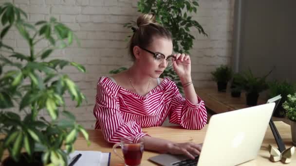 Souriant homme d'affaires heureux assis à la table, regardant l'écran de l'ordinateur portable, ayant un appel vidéo. Jeune femme d'affaires ayant un appel vidéo. Une belle femme travaille sur son ordinateur portable . — Video