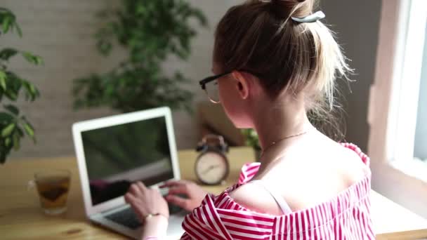 Empresário feliz sorrindo sentado à mesa, olhando para a tela do laptop, tendo uma chamada de vídeo. Uma jovem empresária a fazer uma videochamada. Uma mulher bonita está trabalhando em seu laptop . — Vídeo de Stock