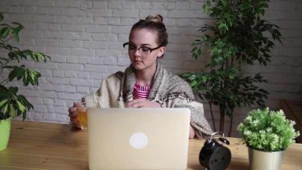 Ritratto di una ragazza frustrata che si soffia il naso in un fazzoletto mentre lavora con un portatile. Il concetto di lavoratore malato infelice . — Video Stock