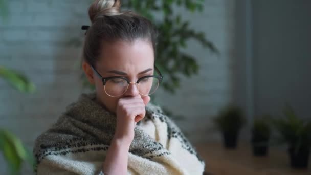 Portrait of a frustrated girl blowing her nose in a handkerchief while working with a laptop. The concept of an unhappy sick worker. — Stock Video