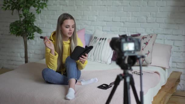 面白い女性ブロガーの記録ビデオ。ベッドの上に座って女の子美容ブロガーがあなたのブログにビデオを書き込みます. — ストック動画