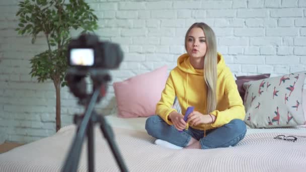 Mujer divertida blogger grabación de vídeo. Chica belleza blogger sentado en la cama, escribe un video a su blog . — Vídeos de Stock