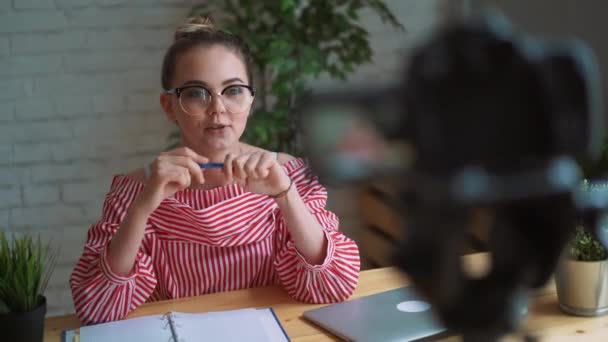 Schönes Mädchen, das Video auf Kamera im Büro aufnimmt. Modeblogger-Konzept. — Stockvideo