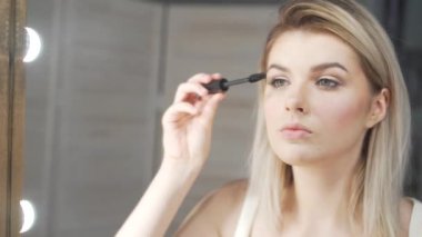 fırça ile gözkapağı makyaj uygulayarak genç güzel kadın