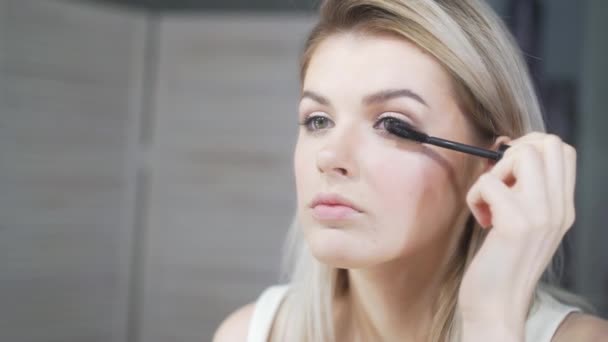 Giovane bella donna che applica il trucco sulla palpebra con pennello — Video Stock