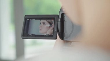 Video işleç. Heyecanlı genç hevesli blogger ise masada oturan ve bir tür özenli arkadaşıyla onu onun kamera kayıt makyaj mutlu hissediyor.