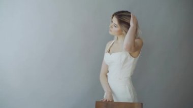 Gri arka plan üzerinde duran ve kameraya bakarak mutlu çekici kız