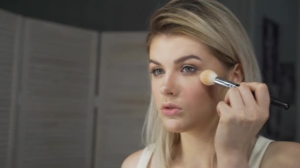 Maquillaje. Joven hermosa chica haciendo maquillaje con cepillo en las mejillas . — Vídeos de Stock