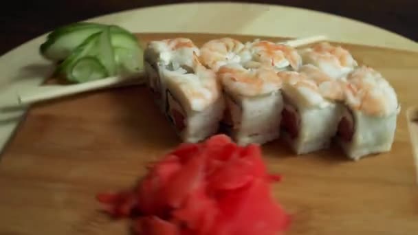Sushi fresco, rollos en la mesa. Fondo oscuro. Palitos de sushi . — Vídeo de stock