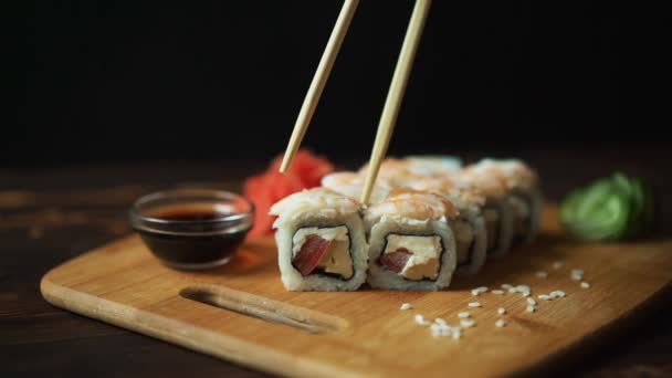 Sushi fresco, pãezinhos na mesa. Fundo escuro. Palitos de sushi . — Vídeo de Stock