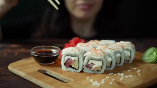 年轻女子在咖啡馆里用筷子吃寿司 — 图库视频影像