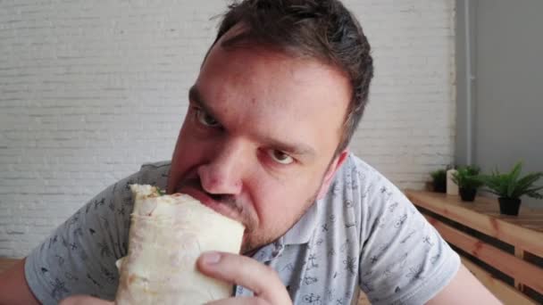 Hombre comiendo Doner Kebap es una cocina de comida rápida del medio oriente — Vídeo de stock