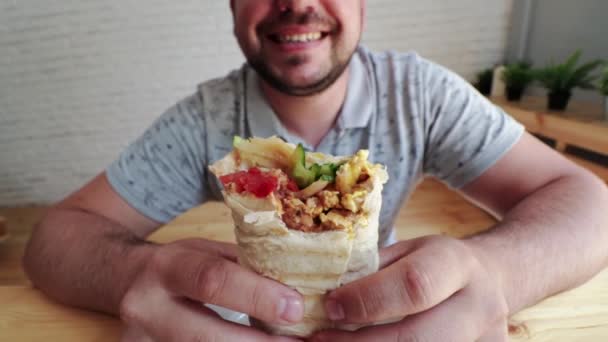 Homem comendo Doner Kebap é uma cozinha midlle fast food oriental — Vídeo de Stock