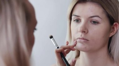 Kadın kozmetik büyük makyaj fırça ile uygulama Close-up. Salon makyaj, kızlarda uygulamak tozu cilt, Vakfı