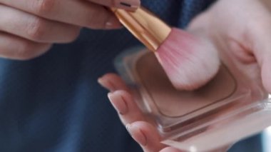 Kadın kozmetik büyük makyaj fırça ile uygulama Close-up. Salon makyaj, kızlarda uygulamak tozu cilt, Vakfı