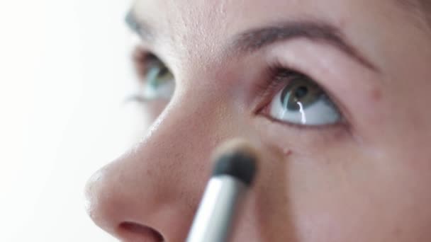 Close-up de mulher aplicando cosméticos com uma grande escova de maquiagem. Meninas no salão de maquiagem, aplicar pó na pele, Fundação — Vídeo de Stock