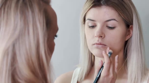 Κοντινό πλάνο Γυναίκα εφαρμογή καλλυντικών με ένα μεγάλο μακιγιάζ βούρτσα. Κορίτσια για το make-up salon, σκόνη εφαρμόζονται στο δέρμα, Ίδρυμα — Αρχείο Βίντεο