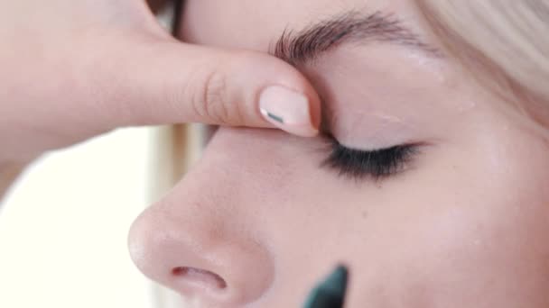 Make-up artist εφαρμογή μακιγιάζ των βλεφαρίδων στο μάτι μοντέλα. Κλείνω πάνω θέα. — Αρχείο Βίντεο