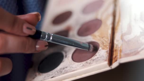 Visagist målar ögonen med ögonskugga en ung flicka — Stockvideo
