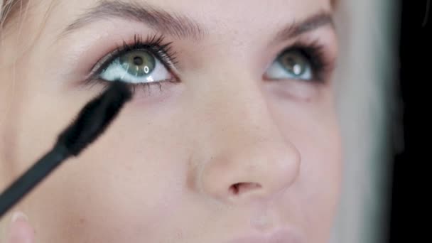 Maquillaje artista aplicando maquillaje de pestañas a los modelos de ojo. Vista de cerca . — Vídeo de stock