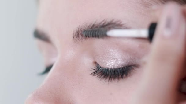 Maquiagem artista aplicando maquiagem cílios para os modelos de olho. Vista de perto . — Vídeo de Stock