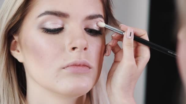 Make-up. Jong mooi meisje make-up met borstel op de wangen maken. — Stockvideo