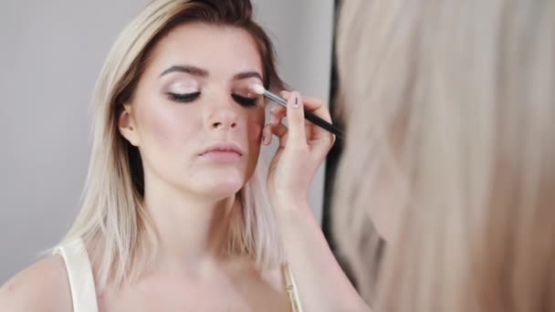 Make-up. Ung vacker flicka att göra makeup med borste på kinderna. — Stockvideo