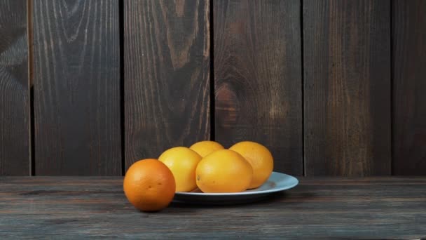 Sinaasappels op de houten tafel — Stockvideo
