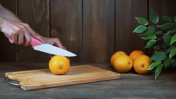 주방에 신선한 오렌지를 절단 하는 여 대 손 — 비디오