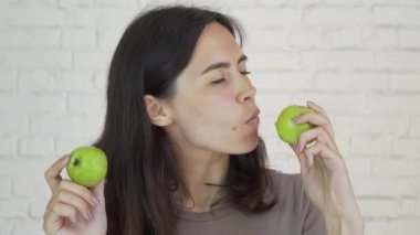 Yeşil elma ve gülümseme yeme dişlerini üzerinde parantez kadın var. Beyaz. Portre