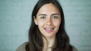 Dişlerde diş telleri. Dişlerini onun ayraçlar gösterilen kız gülümsüyor. Beyaz ve sağlıklı dişler