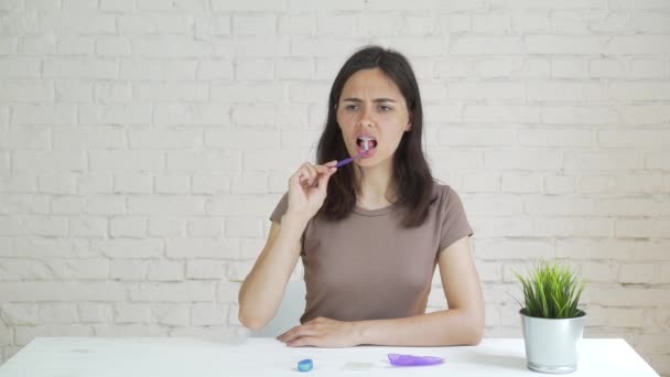 Higiene oral para aparatos ortopédicos. La joven con aparatos dentales se limpia los dientes. Chica adolescente limpiando y cepillando dientes con frenos de cerámica transparente usando herramientas especiales de cepillado . — Vídeo de stock