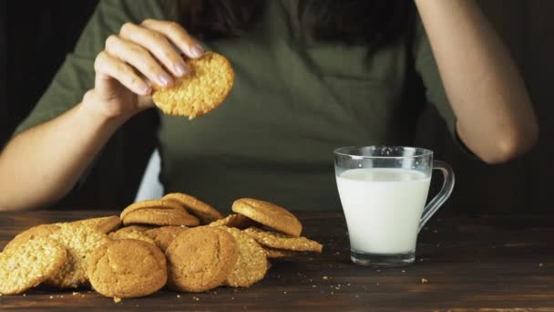 Χέρι βάζοντας ένα cookie σε ένα ποτήρι γάλα σε αργή κίνηση. Κινηματογραφική σκηνή τροφίμων — Αρχείο Βίντεο