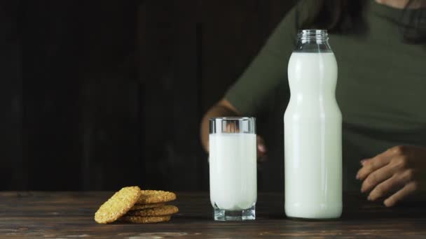 Junges Mädchen auf dem Tisch Kekse und eine Flasche Milch. — Stockvideo