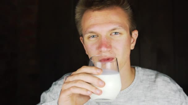Homem bebendo bebida proteica. Um copo de leite nas mãos de um jovem, um SIP de leite fresco — Vídeo de Stock