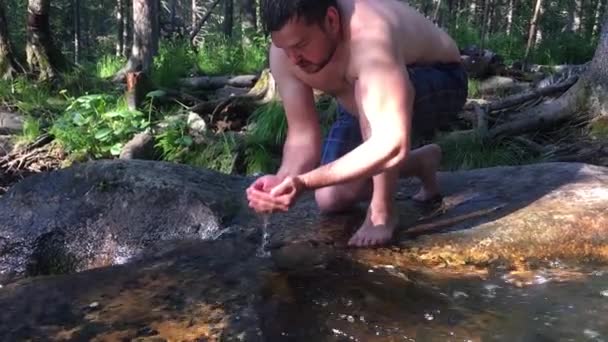 Drick rent vatten från mountain river mans hand absorberas av rent vatten från mountain river. — Stockvideo