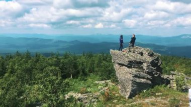 Bir erkek ve bir kız bir dağın tepesinde. Başarı, başarıları ve başarıları ile yaya insanlar kavramı. Turistler dağda iyi eğlenceler. Kampanya.
