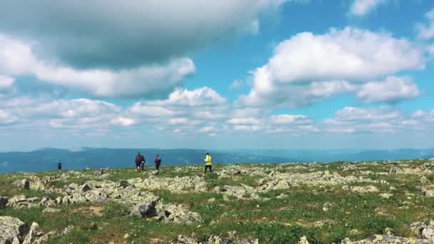 Hiking along the trail on a Sunny day. Group of friends summer adventure travel in mountain nature outdoors. The trip through the mountains. A group of people on top of the mountain. — Stock Video