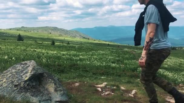 El hombre de la pose victoriosa en la cima de la colina, se sentó a descansar después de un duro camino. Camino de montaña — Vídeos de Stock