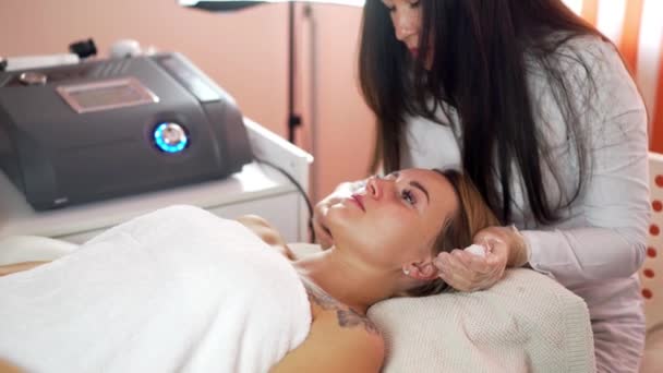 Procédure de nettoyage du visage par ultrasons. Le travail de l'esthéticienne. Ralentir le vieillissement de la peau. Nettoyage des pores, taches noires, saturation en oxygène, cellules mortes de la peau . — Video