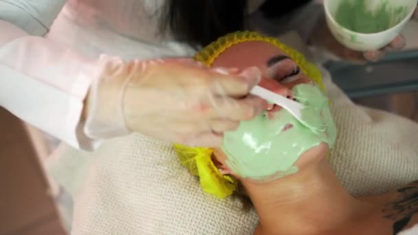 In the beauty salon, the cosmetologist applies an alginate mask to the client. Skin lightening, moisturizing, nutrition, anti-recuperative effect rejuvenation, skin tightening — Stock Video