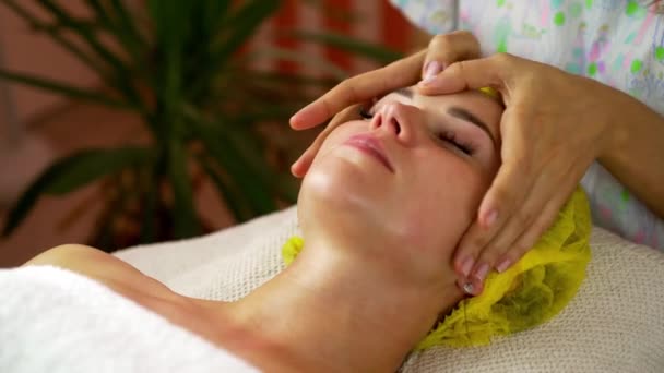 Руки профессиональной массажистки массаж женщина лицо в салоне красоты — стоковое видео