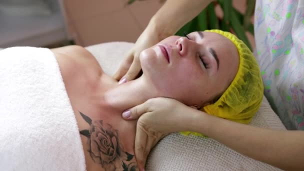 Handen van professionele masseuse masseren vrouw is gezicht op beauty spa — Stockvideo