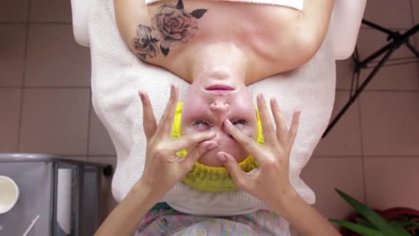 Hands of professional masseuse massaging woman is face at beauty spa — Stock Video